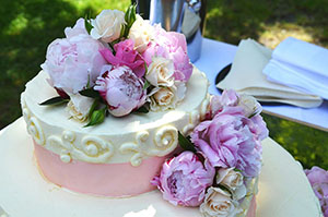 white cake with pink ribbon and flowers
